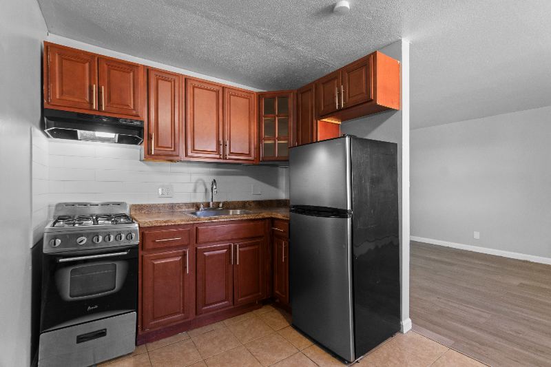 Kitchen with wood cabinets, gas range, and refrigerator